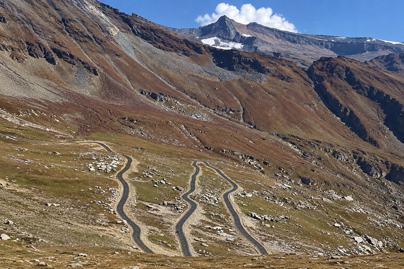 Hairpin switchbacks of the Rohtang Pass road climbing a bare ridge above Manali